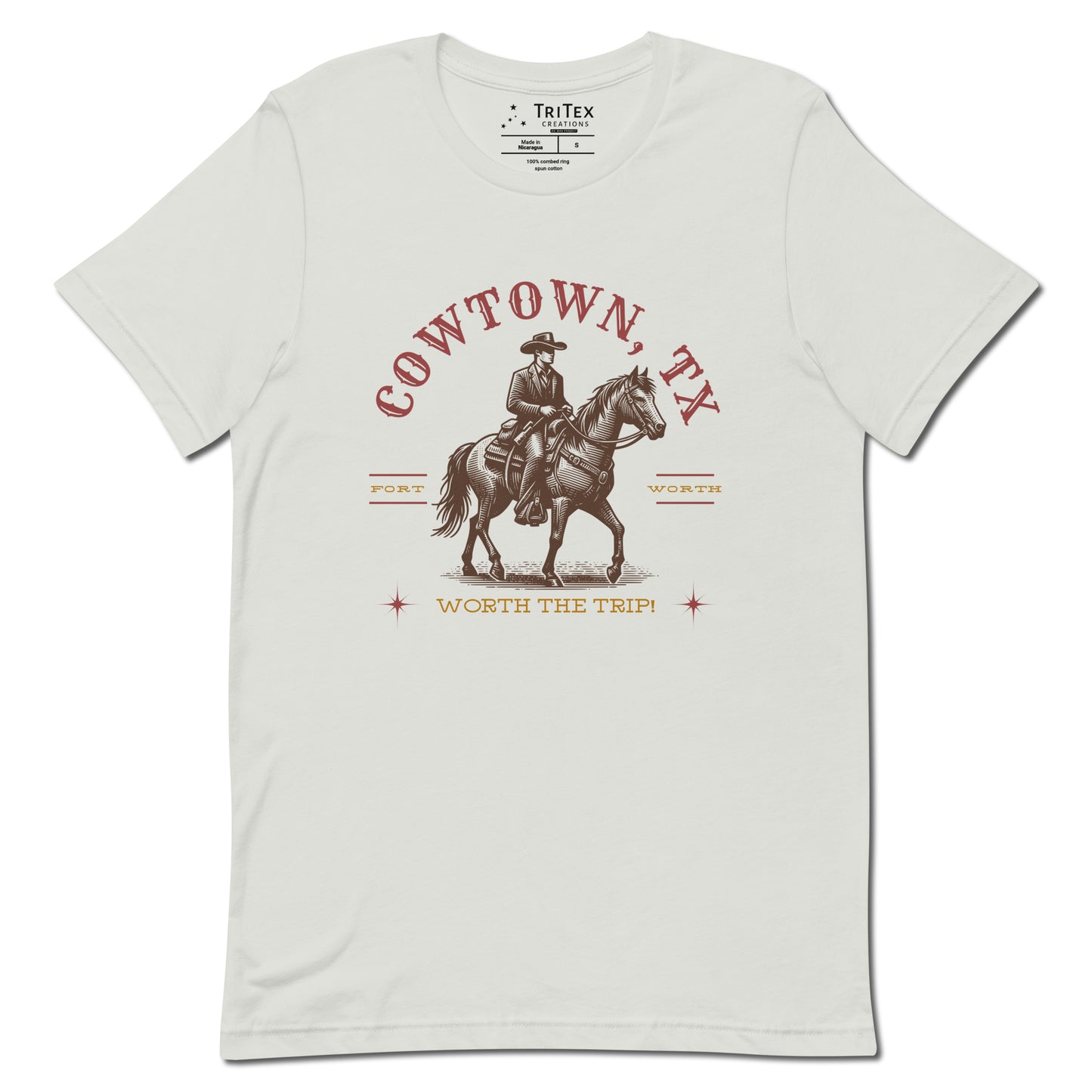 A silver t-shirt featuring a vintage illustration of a cowboy on a horse with the words "Cowtown, TX. Fort Worth. Worth the trip!"