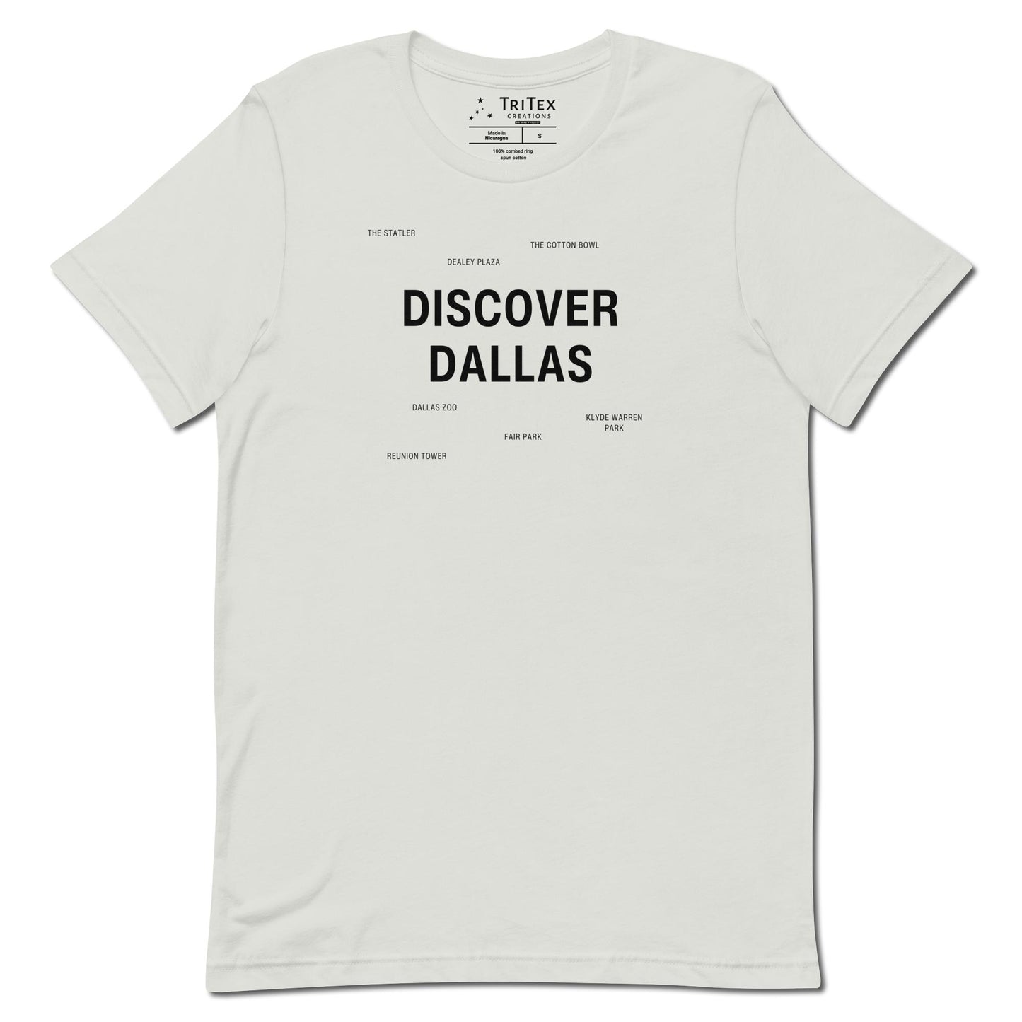 A silver t-shirt which reads "Discover Dallas" in big, bold text with smaller text elements naming Dallas landmarks.