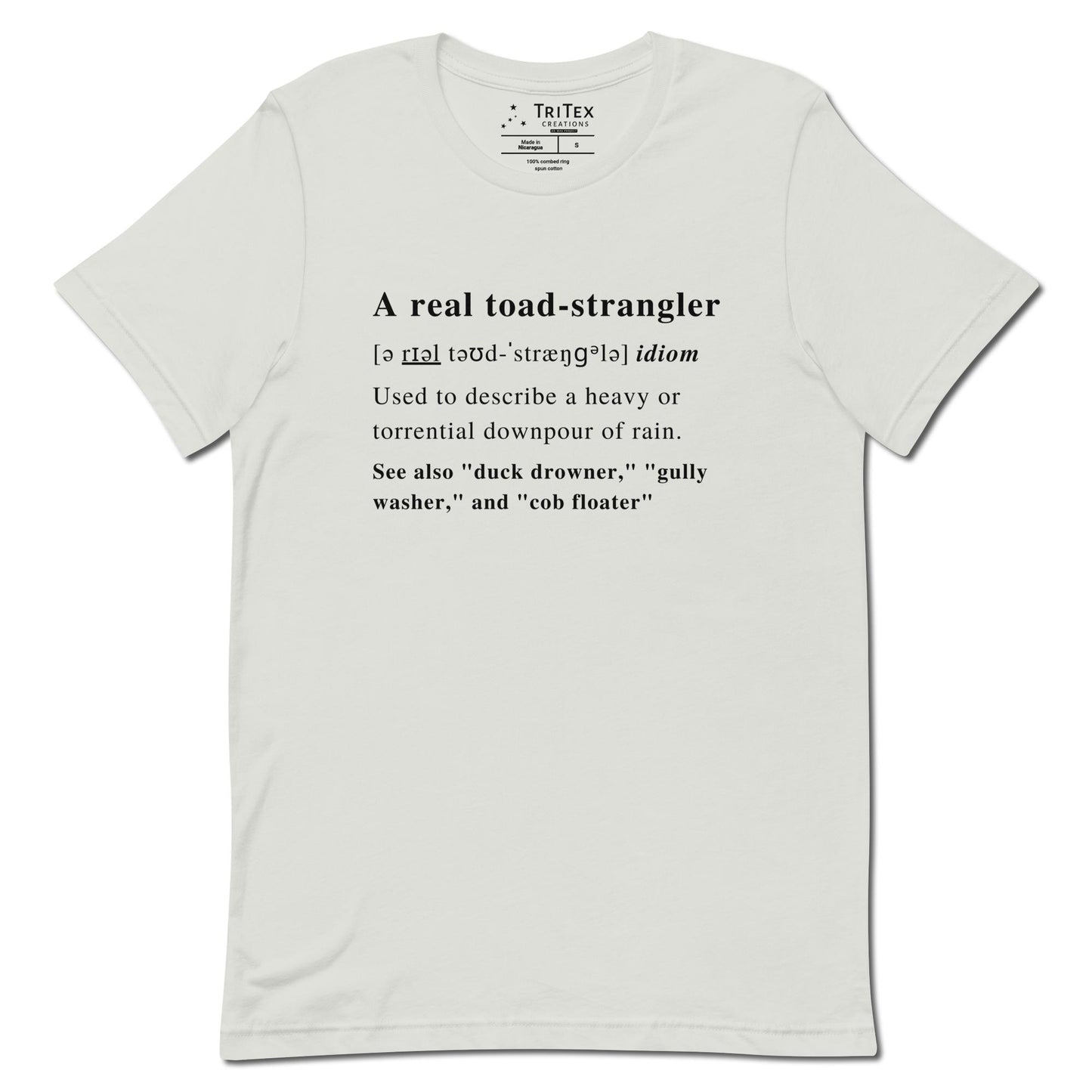 A silver t-shirt that describes the meaning of "A real toad-strangler" in the style of a dictionary entry.