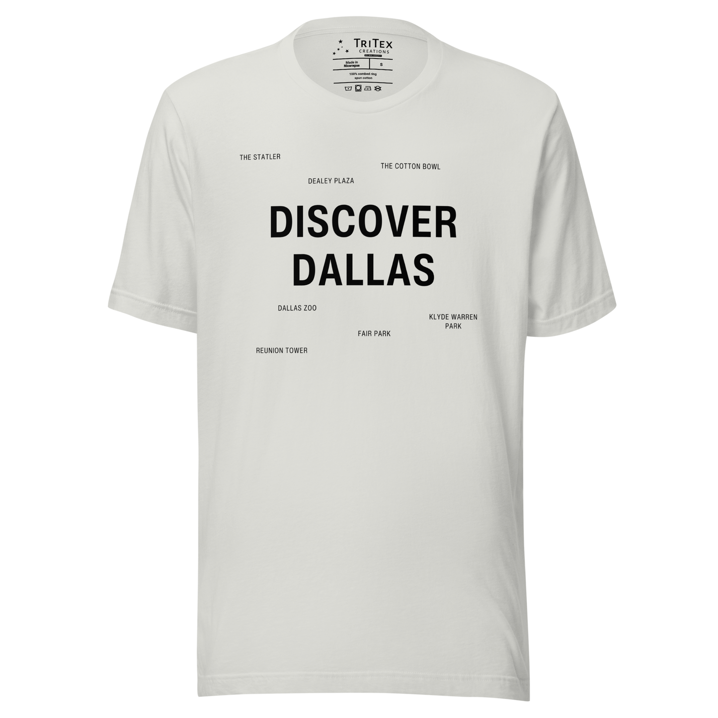 A silver t-shirt featuring "Discover Dallas" in big, bold type surrounded by smaller names of local landmarks.