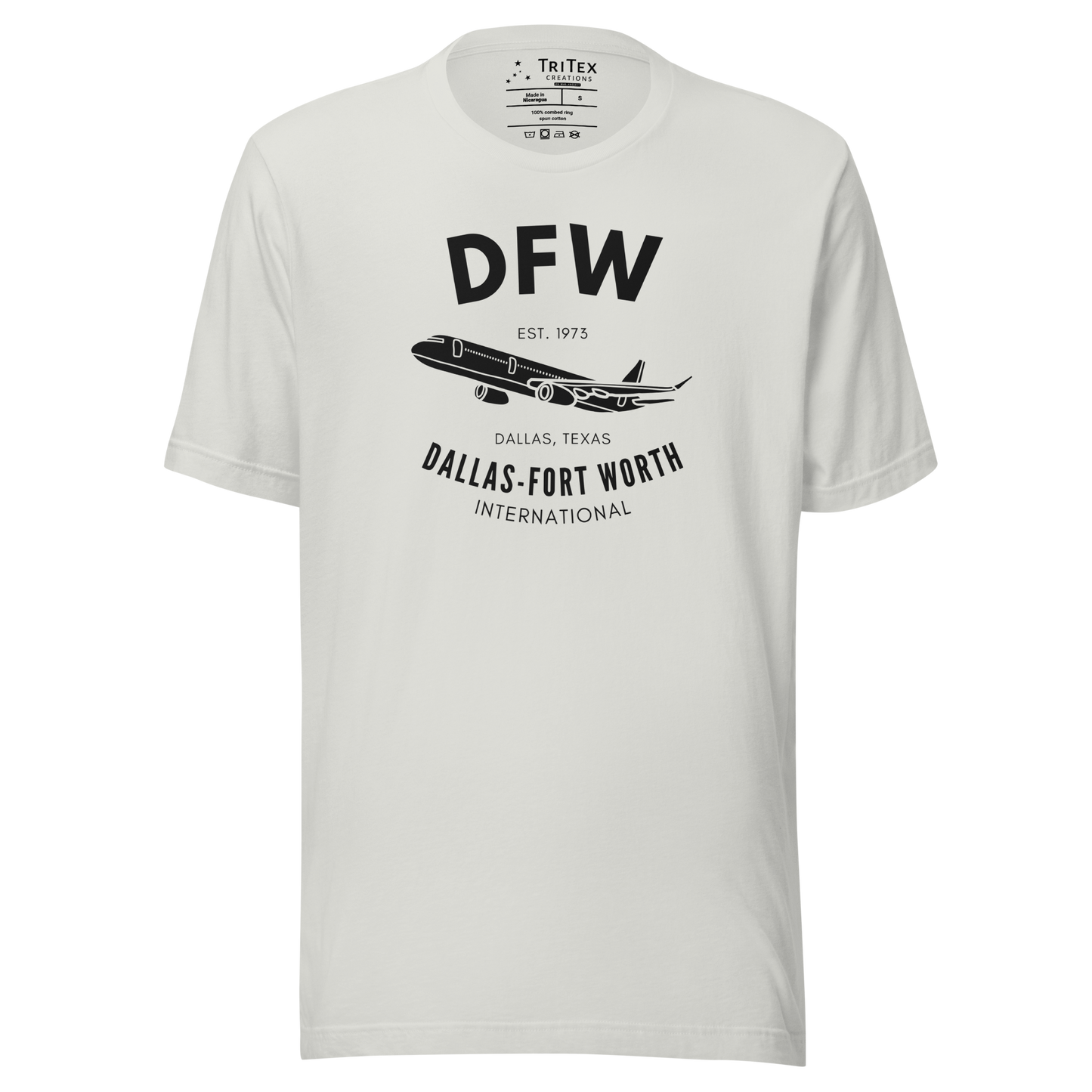 A silver t-shirt featuring a passenger plane and the text "DFW Est. 1973 Dallas, Texas. Dallas-Fort Worth International".