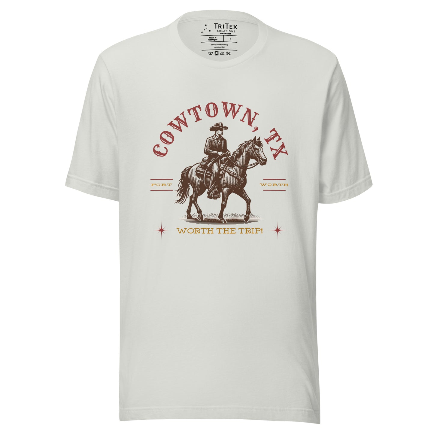 A silver t-shirt featuring a vintage illustration of a cowboy on a horse with the words "Cowtown, TX. Fort Worth. Worth the trip!"
