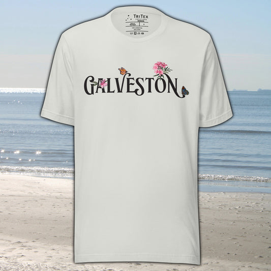A silver t-shirt with the name of "Galveston" amongst oleanders and butterflies.