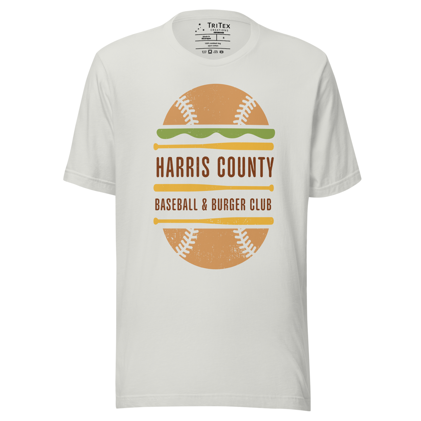 A silver t-shirt featuring a baseball styled like a cheeseburger with text that reads "Harris County Baseball & Burger Club".