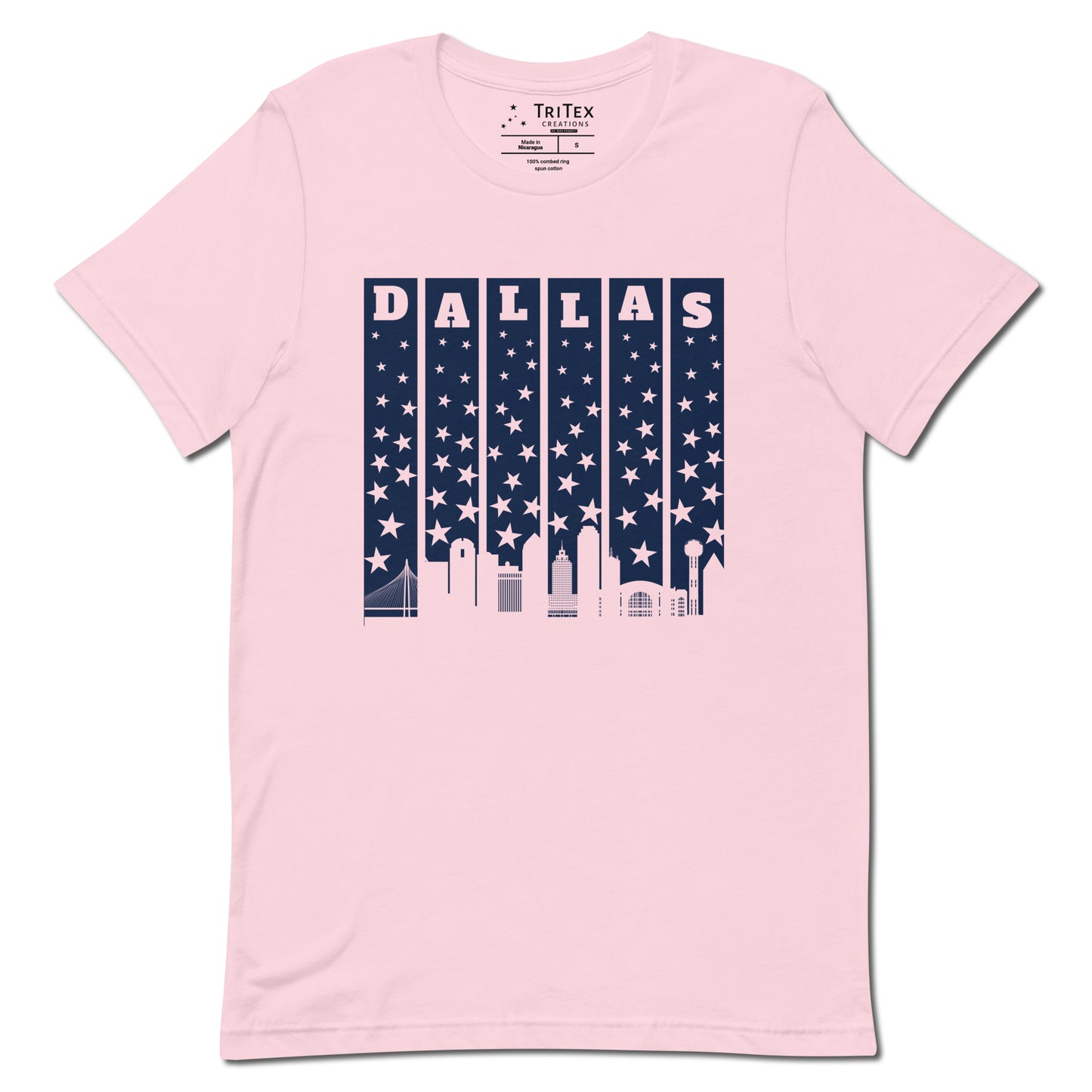 A soft pink t-shirt with with the silhouette of the Dallas skyline underneath some stars and the name "Dallas".