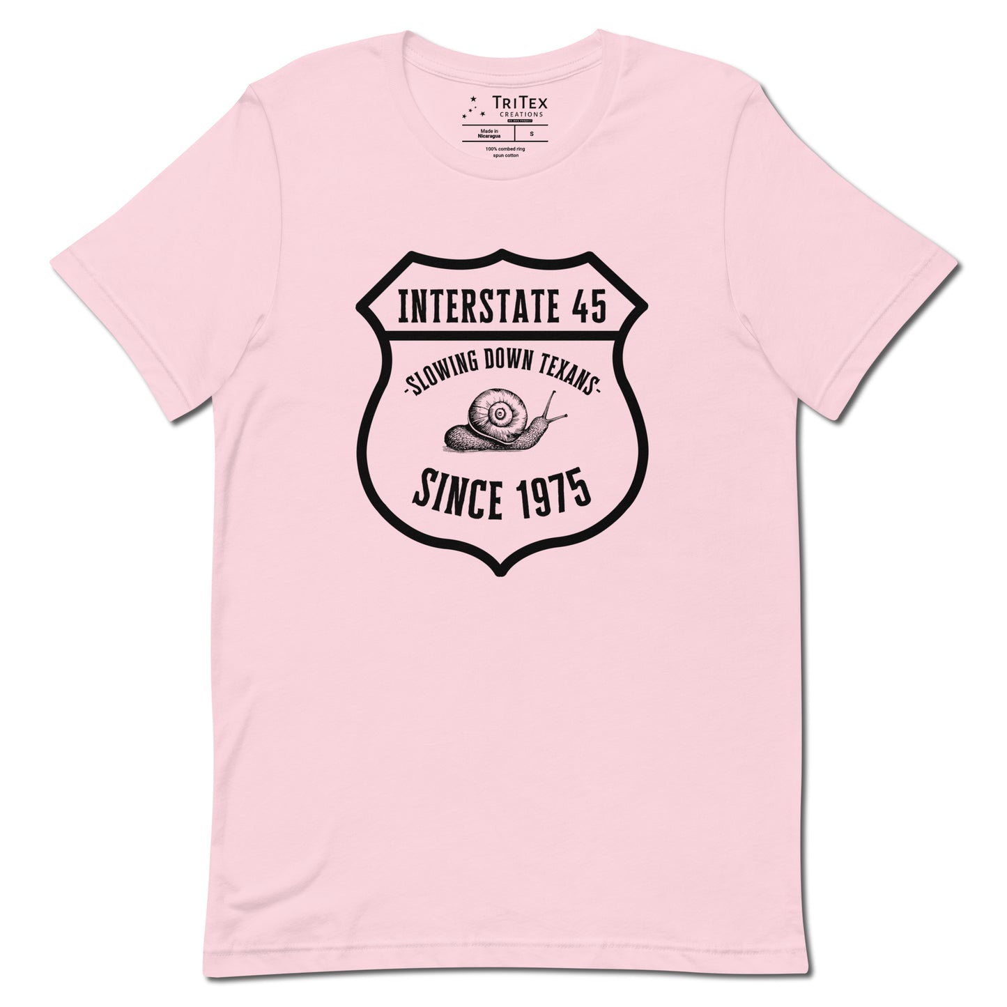 A soft pink t-shirt featuring a vintage illustration of a snail with the text "Interstate 45 slowing down Texans since 1975".