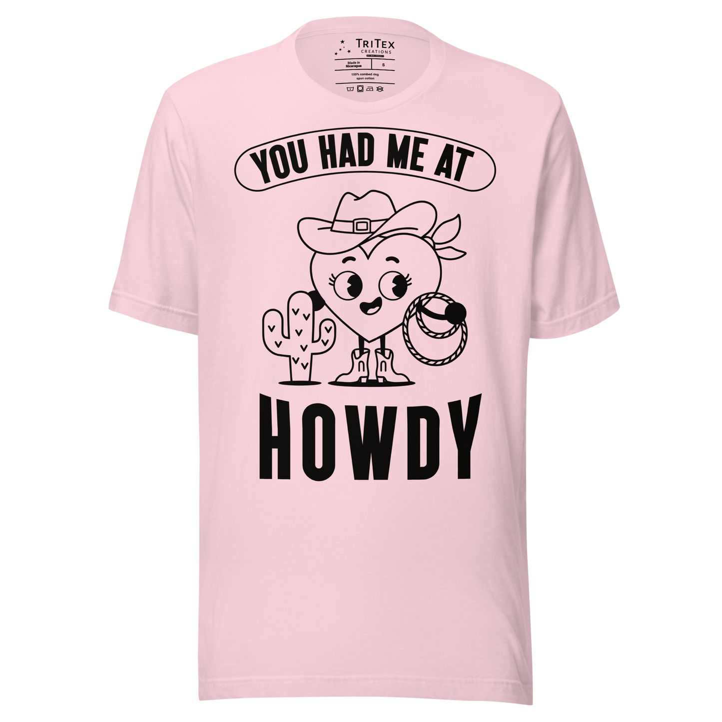 A soft pink t-shirt featuring a cartoon heart dressed like a cowboy with the words "You has me at howdy".