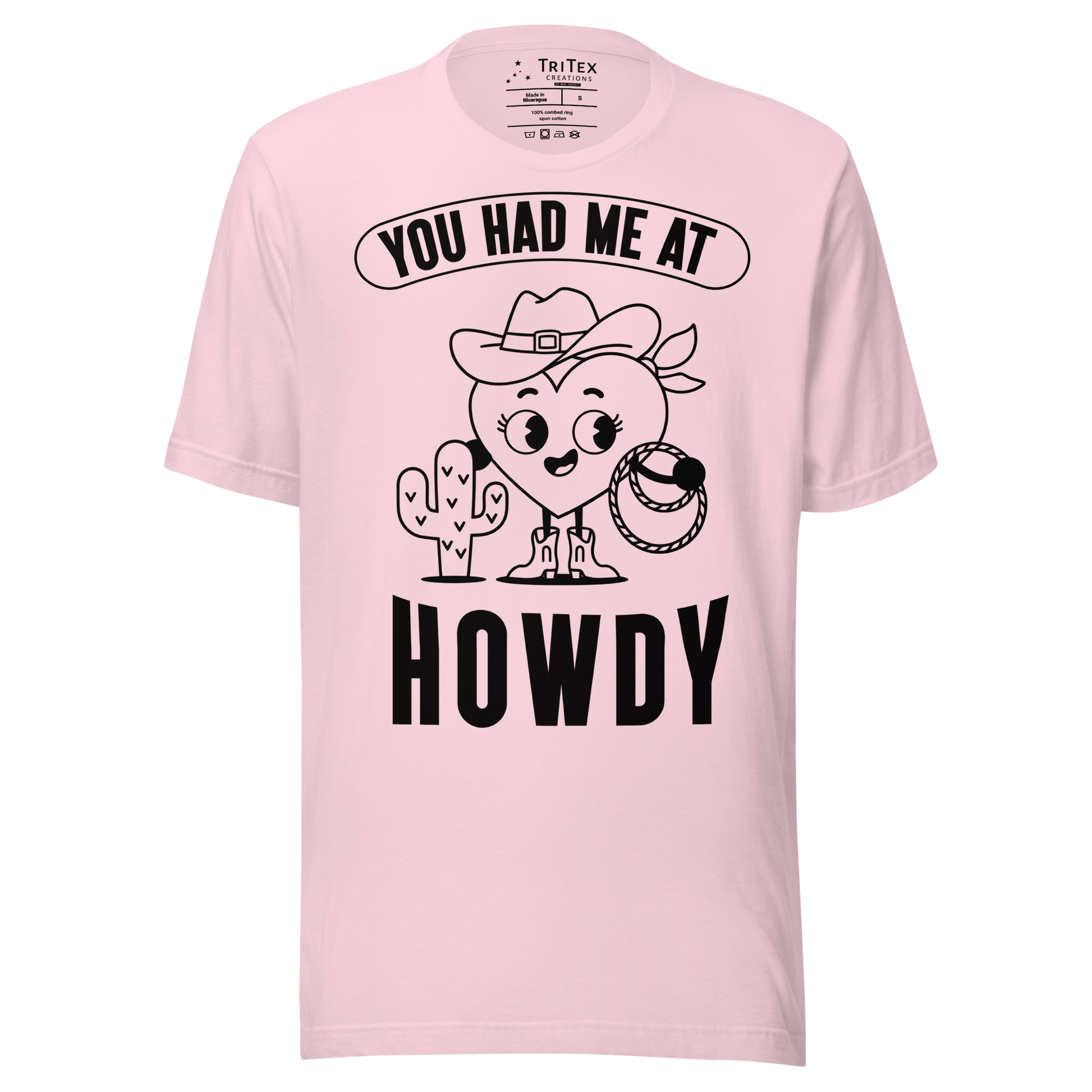 A soft pink t-shirt featuring a cartoon heart dressed like a cowboy with the words "You has me at howdy".