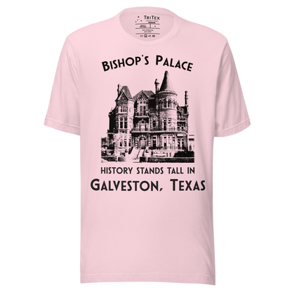 A soft pink t-shirt featuring a vintage-style picture of Bishop's Palace with the text "Bishop's Palace. History stands tall in Galveston, Texas".