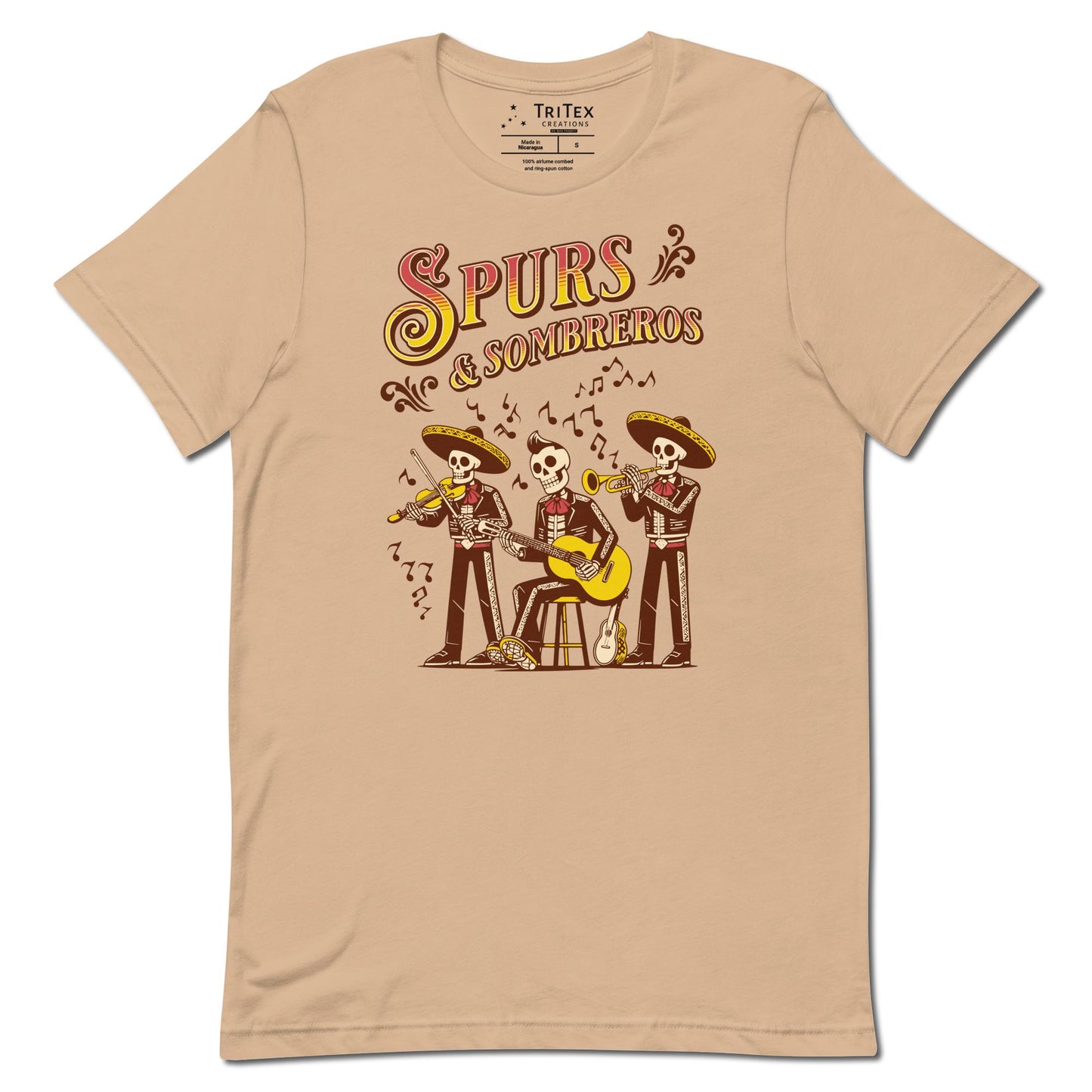 A tan-colored t-shirt featuring some skeleton mariachis playing music with the words "Spurs & Sombreros".