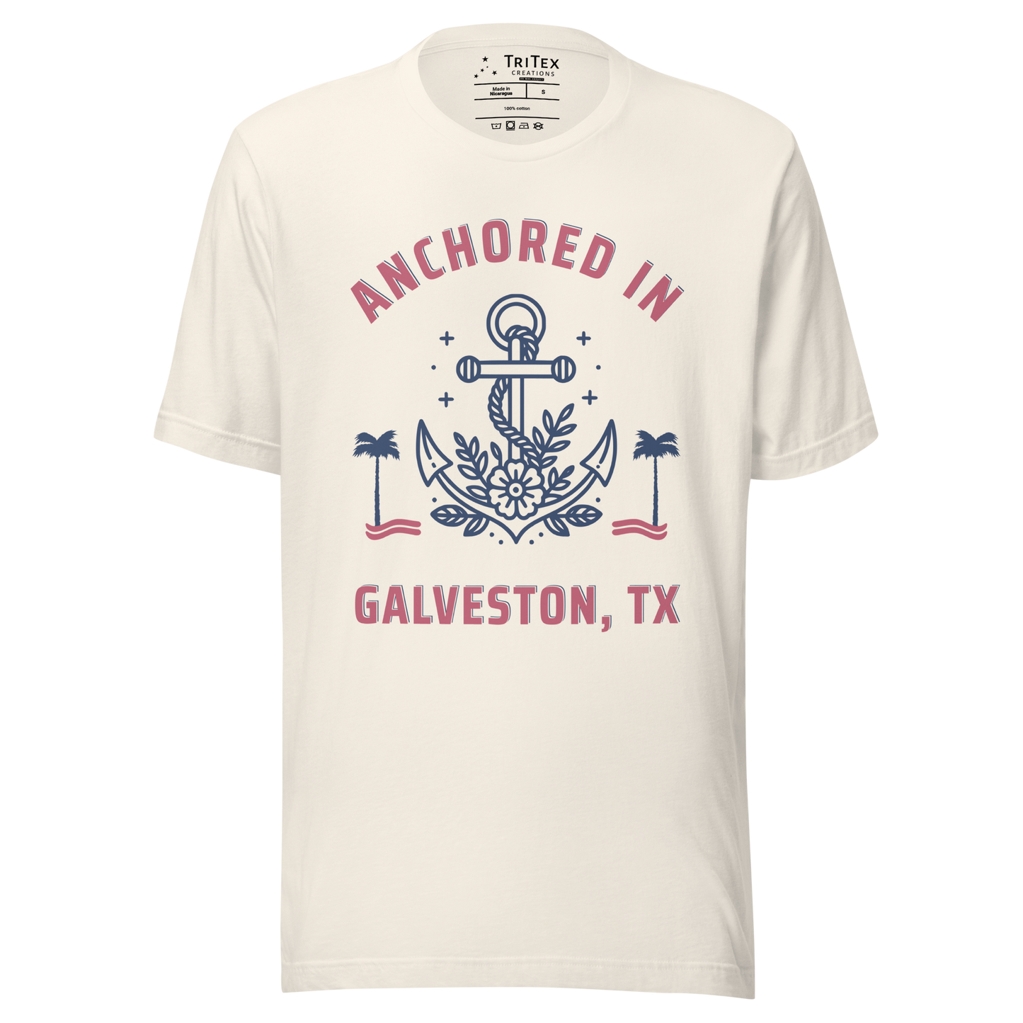 A vintage white t-shirt featuring an image of an anchor, palm trees and a flower with the text "Anchored in Galveston, TX".