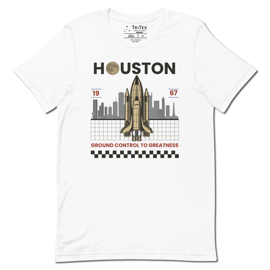 A white t-shirt featuring a space shuttle in front of the Houston skyline and the text "Houston 1967 Ground control to greatness".